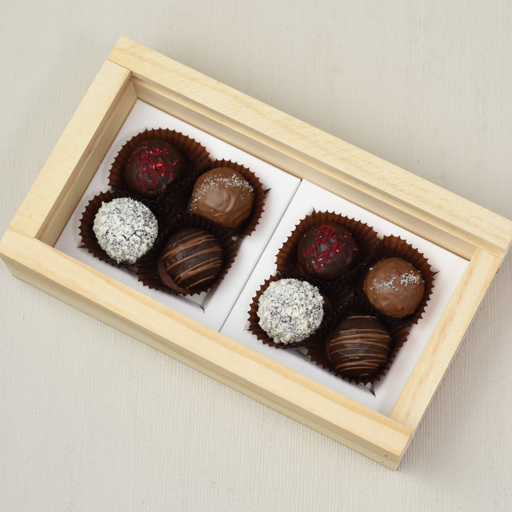 Aroha Chocolate Eight Mixed Truffles Luxury Wooden Gift Box. Top view of an open box of chocolates, showing the beautiful hand made chocolate truffles within, two of each flavour.